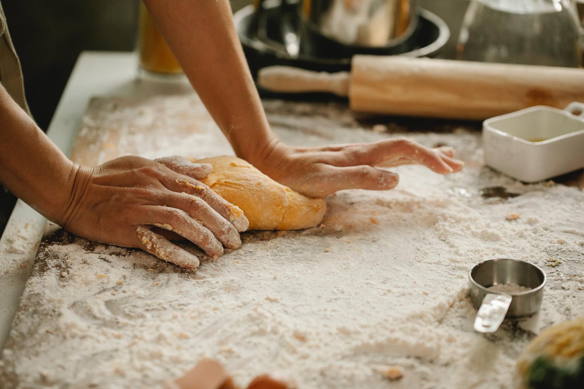 hands preparing dough in small bakery workshop